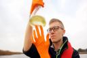 Dr Ben Wagstaff with a sample of water containing the toxic algae.  Picture: James Bass