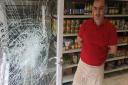 Mohamed Haider, owner of the Norwich Halal Butcher on Magdalen Street next to a damaged door. Picture: Peter Walsh.