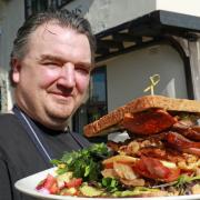 Britons Arms chef-proprietor Richard Ellis with the Ultimate Norfolk Piggy Club Sandwich Picture: Newman Associates PR