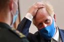Prime Minister Boris Johnson, wearing a face mask, talks with a paramedic during a visit to the headquarters of the London Ambulance Service NHS Trust. Picture: Ben Stansall/PA Wire