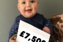 Baby Preston is all smiles as he proudly displays the total amount raised for Gorleston's JPUH neo natal unit at Spencer's Sports Bar in memory of his twin sister Ivy who was stillborn.