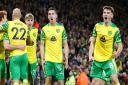 Billy Gilmour and Kenny McLean, centre, celebrate Grant Hanley's goal with the Norwich fans