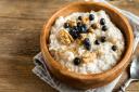 A warm breakfast like porridge - with optional nuts and berries - will give you a great start to the day. Picture: Getty Images