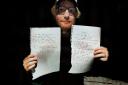 Ed Sheeran with Lot No. 100 - his handwritten lyrics to Perfect. Picture: Courtesy Ed Sheeran: Made in Suffolk Legacy Auction