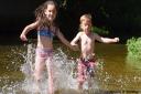 Children cool off in the river at Earlham Park in Norwich. Picture: DENISE BRADLEY