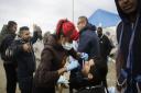 Dentist Raid Ali, center right, and his colleague Aliyo Rashid Taylor, center left, treat migrants with toothache inside Frances biggest refugee camp near Calais, northern France.  (AP Photo/Markus Schreiber)