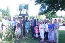Pictured with the restored village sign is parish council chairman councillor Linda Brooks, left of the sign, artist and sign restorer Fiona Davies, right of the sign, and Persimmon Homes Anglia managing director Andrew Fuller, centre right, along with vi