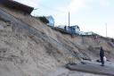 A beachgoer looking at the damage caused by erosion in Hemsby. Picture - Denise Bradley