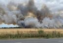 A fire in a Long Stratton spread quickly across the field in a matter of minutes, sending plumes of smoke into the air