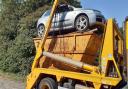 A truck transporting a car precariously perched on top of a skip was stopped by police for travelling with an insecure load in Lowestoft