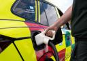 A paramedic charges one of the new electric rapid response vehicles, the Skoda Enyaq iV 80x, which is being trialled by the East of England Ambulance Service NHS Trust