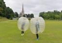 Zorbing on the Memorial Field in front of the church at Snettisham