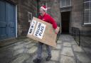 Brian Mansley carries a sign, one of hundreds that are being dispatched to polling stations around Scotland from the Old Royal High School in Edinburgh, ahead of the General Election. PA Photo. Picture date: Wednesday December 11, 2019. See PA story