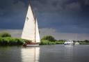 Boats sail on the Norfolk Broads in Ludham