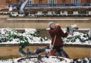 Student Summer Loh feeding the pigeons at the war memorial in Norwich