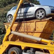 A truck transporting a car precariously perched on top of a skip was stopped by police for travelling with an insecure load in Lowestoft