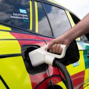 A paramedic charges one of the new electric rapid response vehicles, the Skoda Enyaq iV 80x, which is being trialled by the East of England Ambulance Service NHS Trust