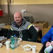 Adam Hale-Sutton and others eating a meal at an aid drop off point after 20 hours of driving.