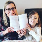 Michelle Gant, of Dereham, with her four-year-old daughter Thea, and the book When the World Paused