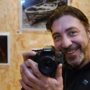 Recovering drug addict Richard Walsh, who turned to photography in 2020, in front of his work