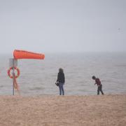 A family on the empty beach as the wind and rain hits Great Yarmouth sea front. Picture: DENISE BRADLEY