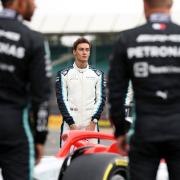 George Russell checks out the 2022 car on the grid ahead of the British Grand Prix at Silverstone - with Lewis Hamilton and Valtteri Bottas watching on