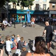 A previous year of Head Out, Not Home in Norwich, with audiences watching performer William Sanchez in London Street.