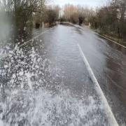 Photographer Terry Harris drives through the flooded A1101 at Welney.