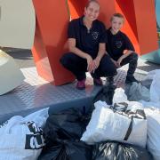 Litter activist Theo Yeldham and mum Hannah with bags of rubbish collected at a volunteer litter pick organised by Theo.