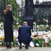 The Prince and Princess of Wales view floral tributes left by members of the public at the gates of Sandringham House in Norfolk