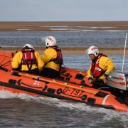 A woman and her dog were rescued after being cut off by the tide in Wells