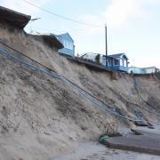 A beachgoer looking at the damage caused by erosion in Hemsby. Picture - Denise Bradley