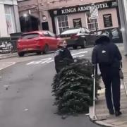 A police officer was seen dragging a town's stolen Christmas tree