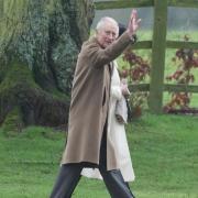 The King was seen waving while walking into church at Sandringham this morning