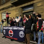 Acorn protestors stand outside City Hall during a demonstration against the use of bailiffs