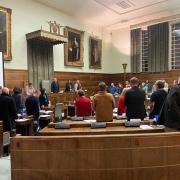 Councillors stand as lord mayor Paul Kendrick arrives at Norwich City Hall during a full council meeting this week