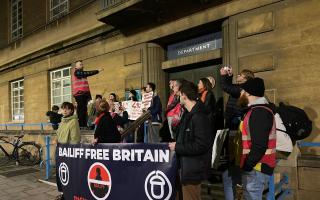 Acorn protestors stand outside City Hall during a demonstration against the use of bailiffs